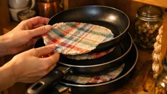 Transformă prosoapele de bucătărie vechi în protectoare pentru tigăi: truc simplu care previne zgârieturile